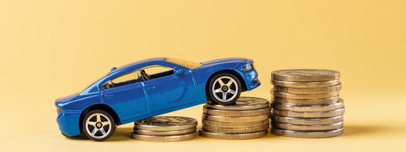 A blue toy car stacked on coins rising in amount from left to right.