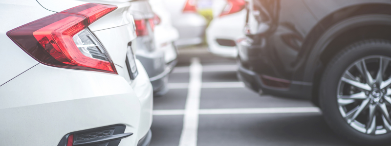 A close up of the rear of cars parked up.