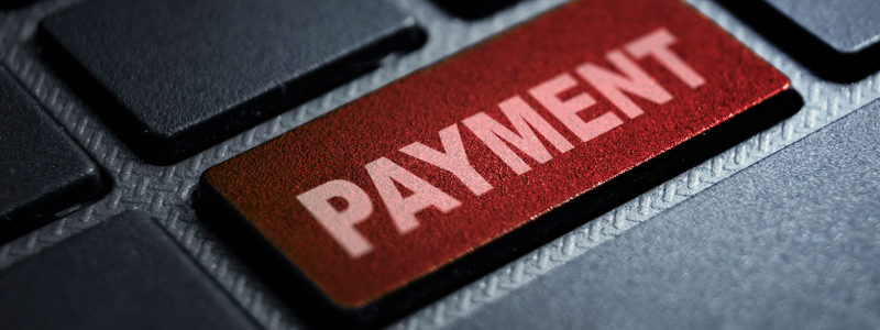 A close up of a red key on a keyboard, reading out 'payment', symbolising online payments.