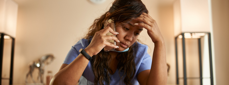 A person appearing stressed on a phone call, showing fear of ringing someone.