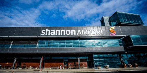 The front of Shannon Airport, with the large sign in view and blue skies in the background.